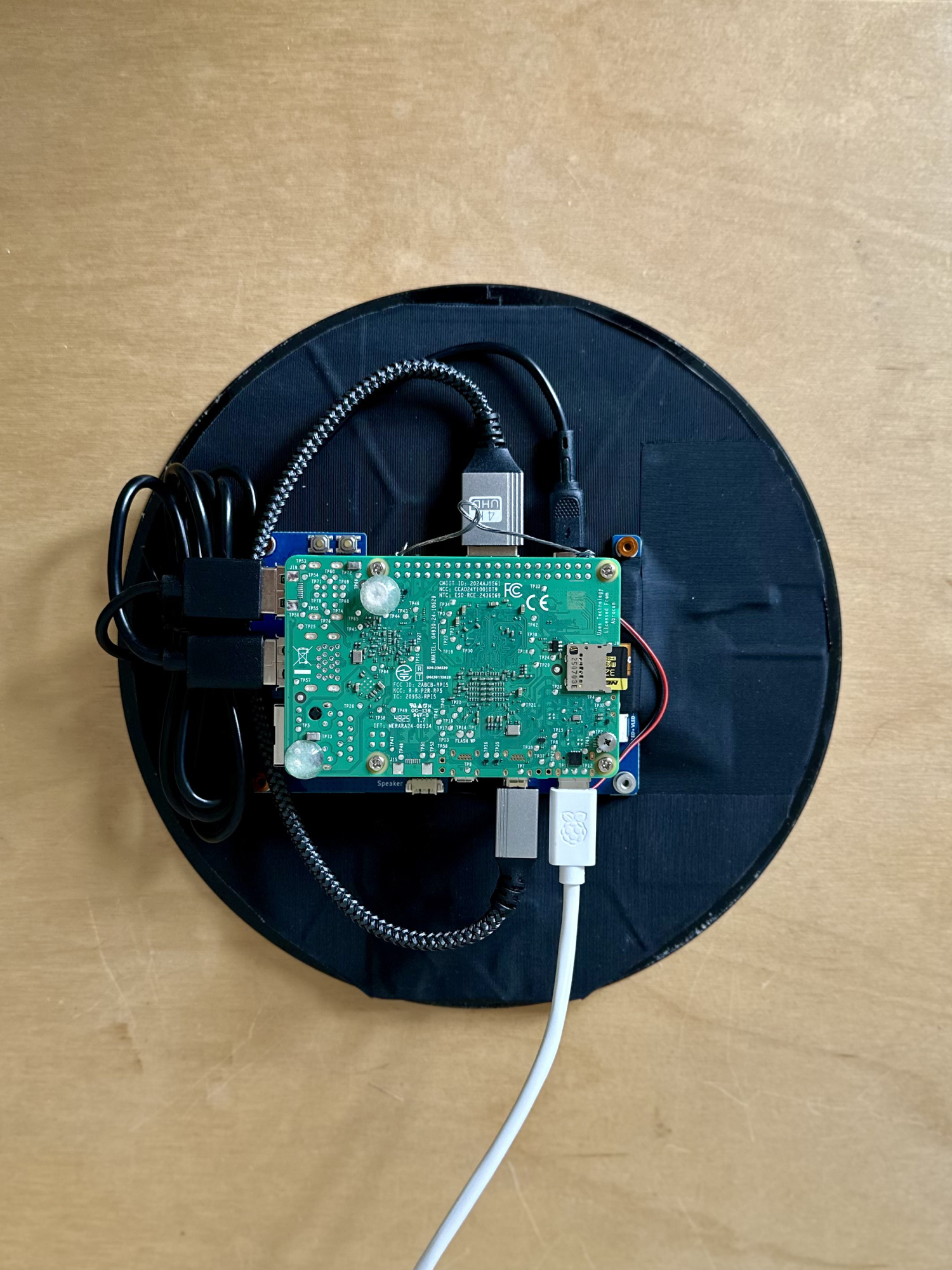 The back of the eona device showing the Raspberry Pi 5 board wired into the round display housing